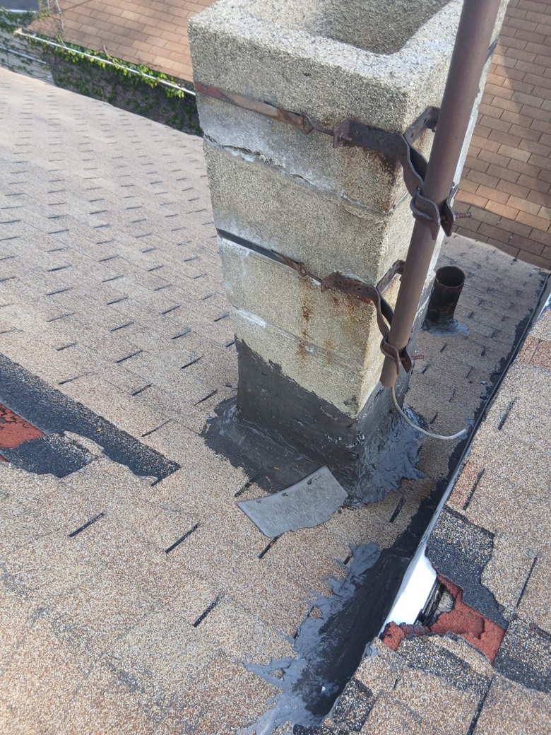 New chimney flashing and freshly sealed shingles on a repaired GRA roof