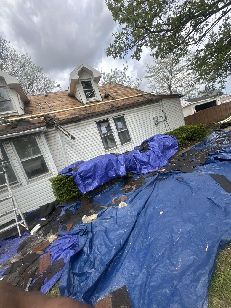 GRA crew tearing off an old roof with tarps protecting the home's landscaping